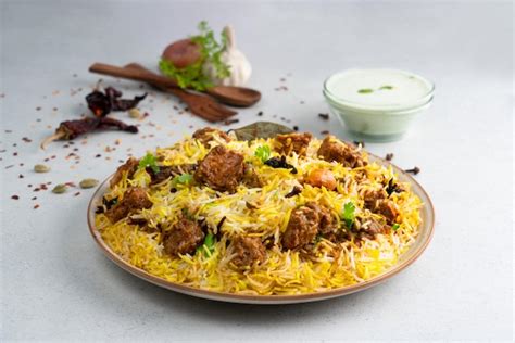 Premium Photo | Indian spicy mutton Biryani with raita and gulab jamun ...