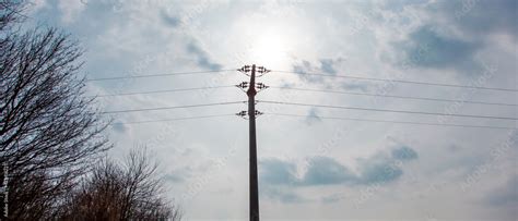 High voltage tower, power line in silhouette against blue sky with ...