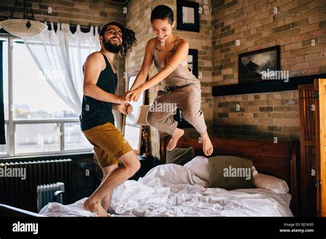 Couple jumping on bed Stock Photo - Alamy