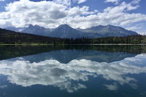 A mirror-like Lake Clark reflects the scenery Lake Clark National Park ...