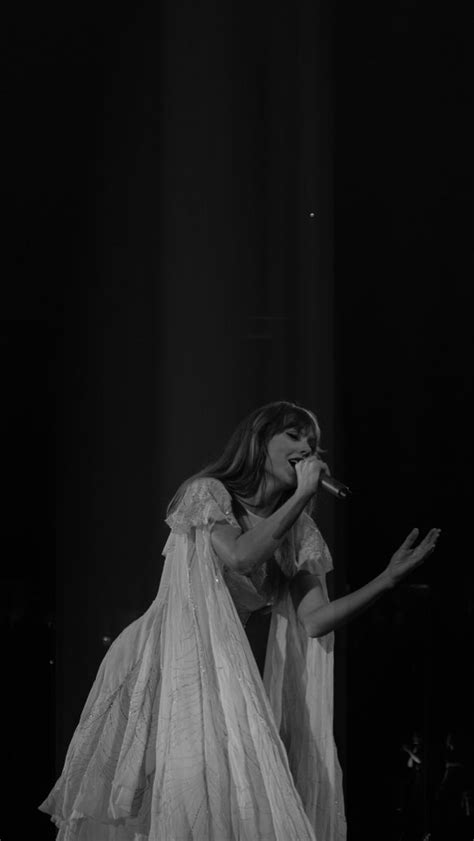 a woman in white dress on stage with microphone