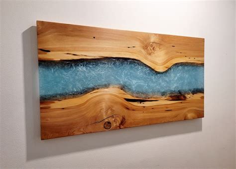 a piece of wood with blue paint on it hanging on the wall next to a ...