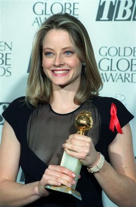 a woman holding an award in her right hand and wearing a black dress ...