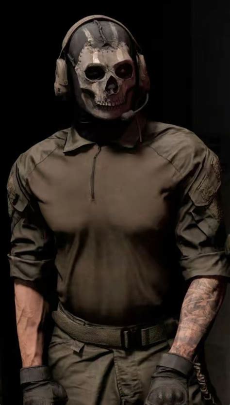 a man wearing a helmet and gloves with a skull on his face is standing ...