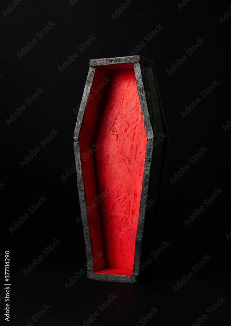 Miniature open black-red coffin on a black background. Festive halloween concept. A place for ...