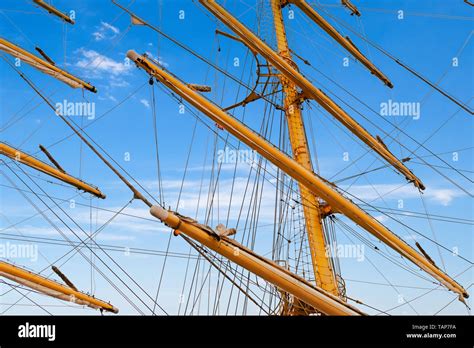 Wooden masts, spars and rigging of the sailboat against the blue ...