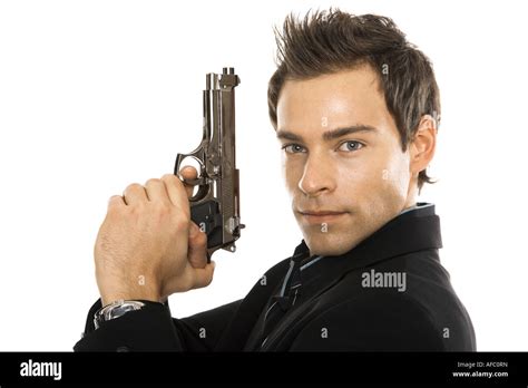 Young man holding hand gun, close-up Stock Photo - Alamy