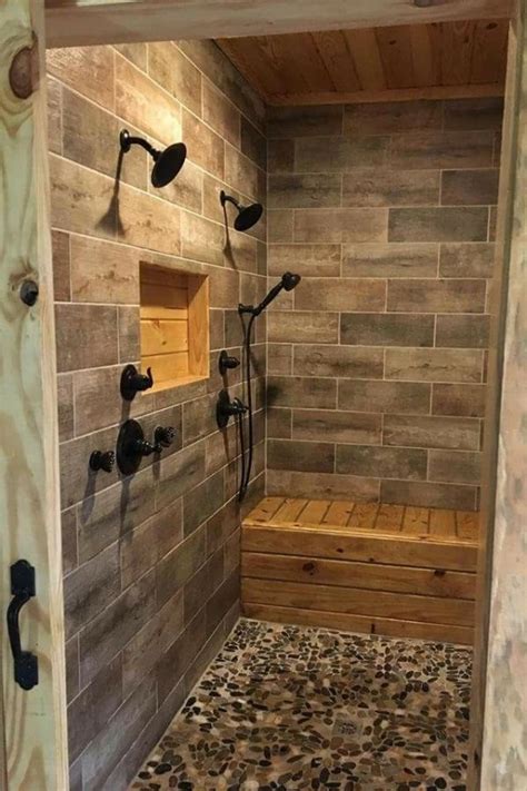 a walk in shower sitting next to a wooden bench on top of a tiled floor