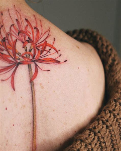 Watercolor style red spider lily tattoo on the upper