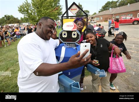 Coleman Middle School teacher Sean Gates takes a selfie with Oscar the Robot and his students ...