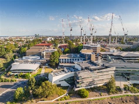 Image of Aerial view of a large University campus with large construction cranes above ...