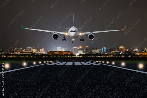 Airplane take off / landing at night with blurred town on background Stock Photo | Adobe Stock