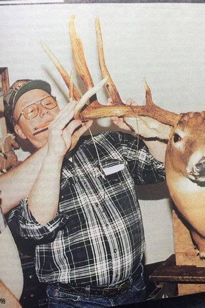 a man holding up a deer's antlers in front of him with his hands