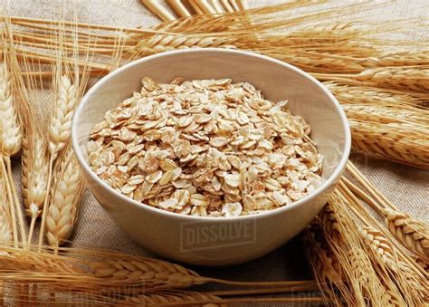 Bowl of rolled oats and cereal ears - Stock Photo - Dissolve