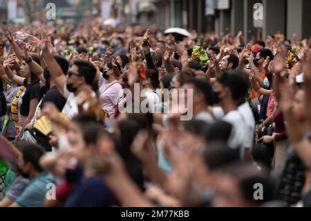 Filipino Catholics wave their hands in the air and hold up Santo Nino ...