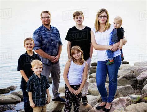 Outdoor portrait of a family with five young children standing on rocks ...