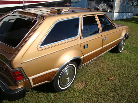 a gold station wagon parked in the grass