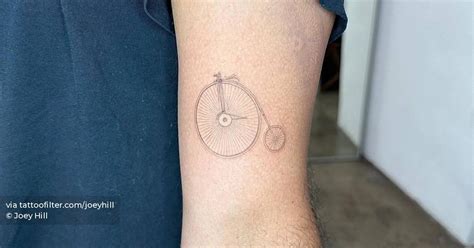 Single needle penny-farthing tattoo located on the