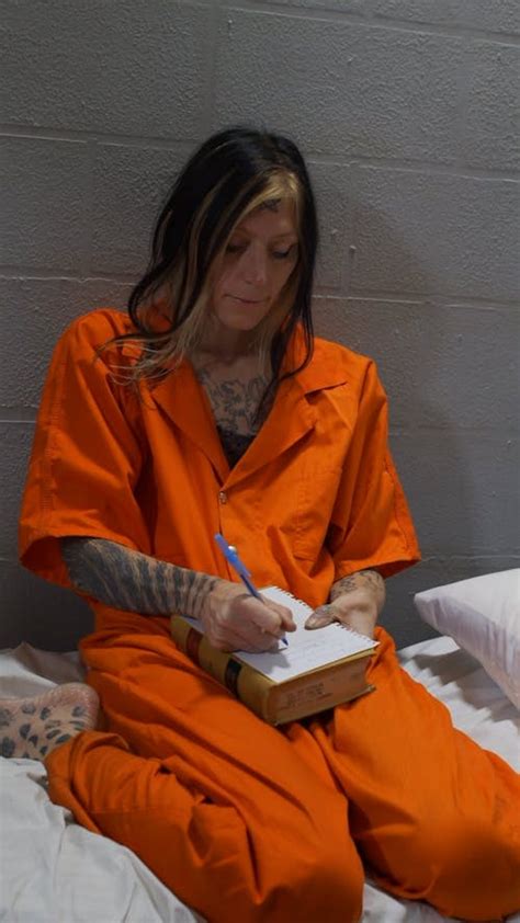 Tattooed Female Inmate Standing Against the Jail Cell · Free Stock Video