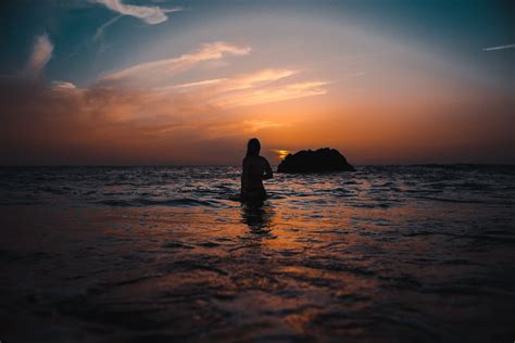 Silhouette of Woman On Ocean During Sunset · Free Stock Photo