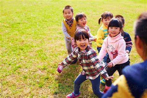 "Happy Asian Kids Playing Outdoor In The Park" by Stocksy Contributor "Bo Bo" - Stocksy