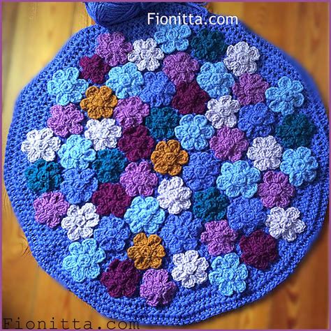 This flower rug is made up of different coloured flowers that are sewn together with crocheted ...