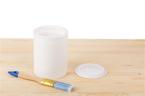 Premium Photo | White paint with a brush on a wooden background with texture