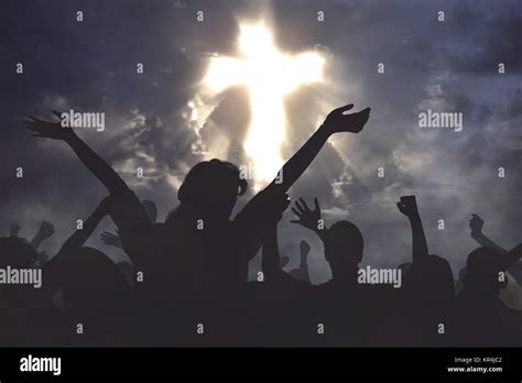 Crowd of christian people praying together to god with dramatic sky ...