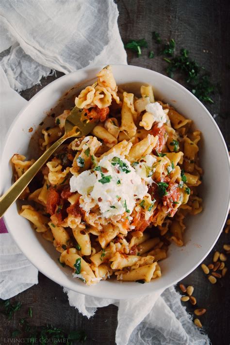 a white bowl filled with pasta covered in sauce and parmesan cheese on top