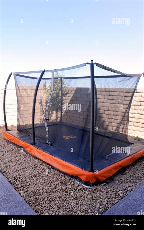 Square residential backyard "in ground" trampoline Stock Photo - Alamy