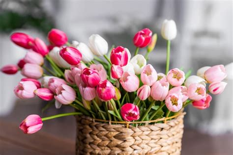 Premium Photo | Closeup Bright colored tulips in a wicker basket on a ...