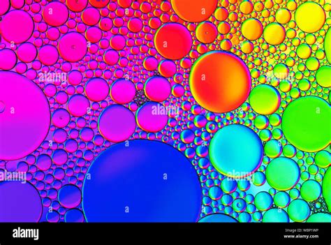 Multicoloured coloured bubble patterns formed by oil floating on water Stock Photo - Alamy