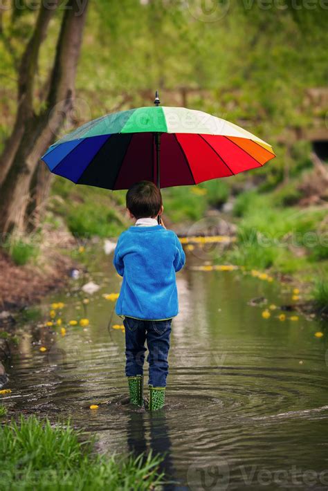 Cute little boy, walking in a pond in the rain 954311 Stock Photo at ...