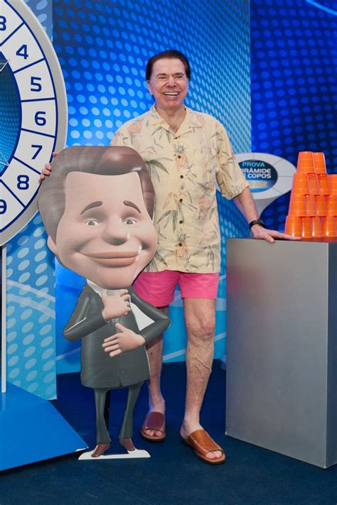 a man standing next to a giant clock with a cartoon character on it