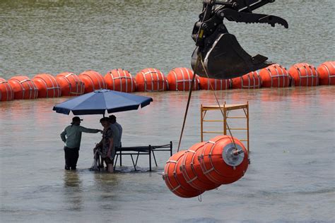 U.S. sues Texas governor over floating barrier to stop migrants in Rio ...