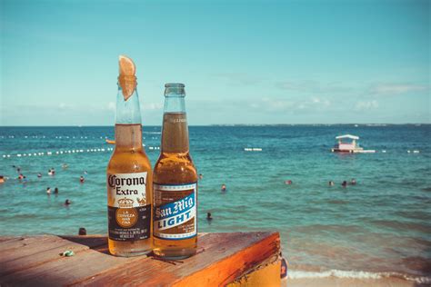 Two Corona Extra and San Mig Light Beers on Top of Brown Wooden Plank ...