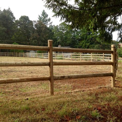 a wooden fence in the middle of a field