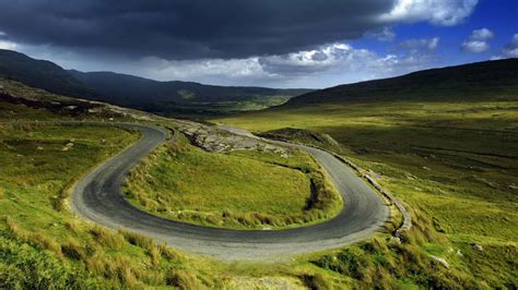 Zigzag road surrounded with grasses under dark heavy clouds HD ...