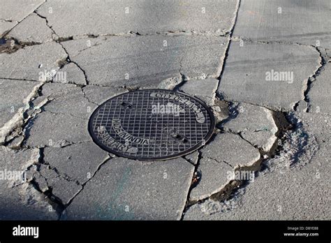 Cracked concrete around manhole cover Stock Photo - Alamy