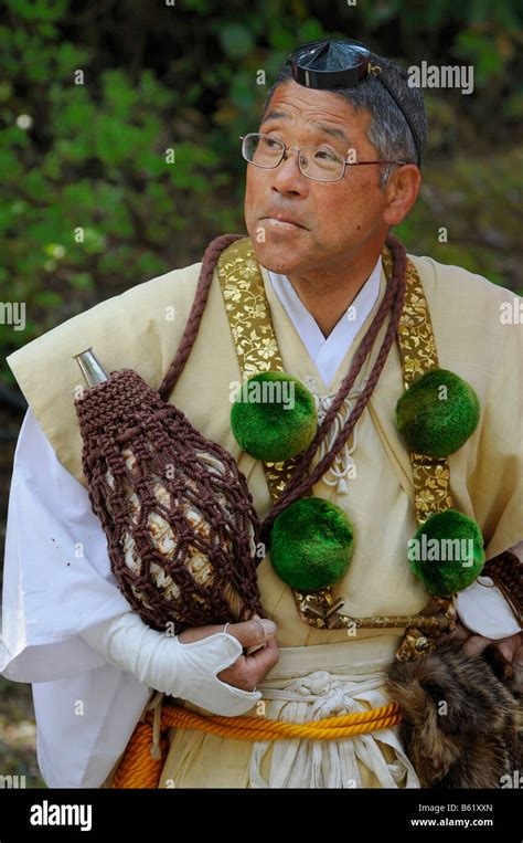 Yamabushi conch shell blower wearing traditional headdress and clothing ...