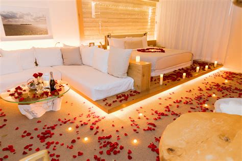 The romantic hotel room decoration in 1 Hotel (Miami). Real rose petals, candles and flowers ...