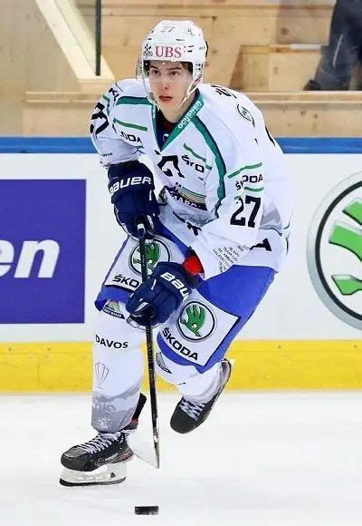 a man in white and blue uniform skating on ice