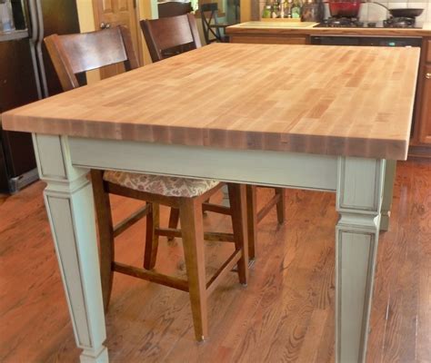 a kitchen island with two stools in front of it and a counter top on ...