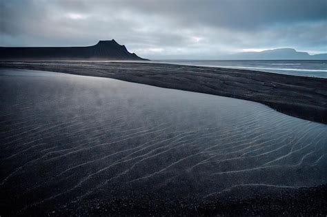 Premium Photo | Dark sea water and sandy beach on iceland beach