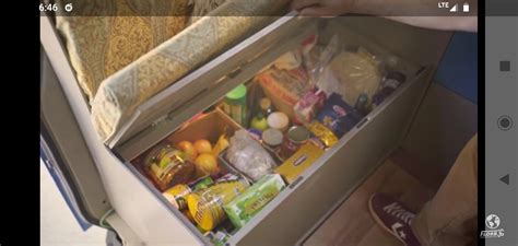 an open refrigerator with food in it and someone holding the door open to show what's inside