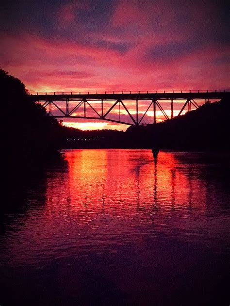 A sunset behind a bridge at the river | Smithsonian Photo Contest ...