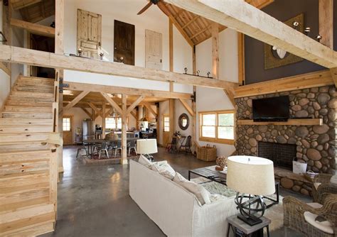 Open floor plan in a barn home with loft living space. Wood post ...