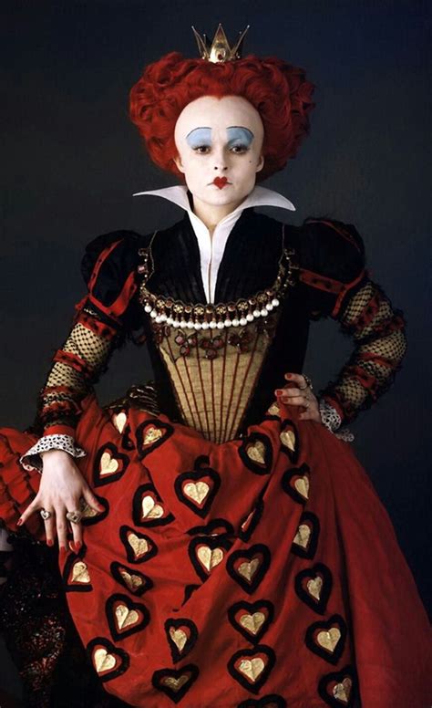 a woman in a red and black dress with hearts on her face, wearing a crown