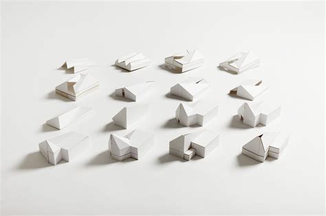 several pieces of white paper are arranged in the shape of an abstract structure on a white surface