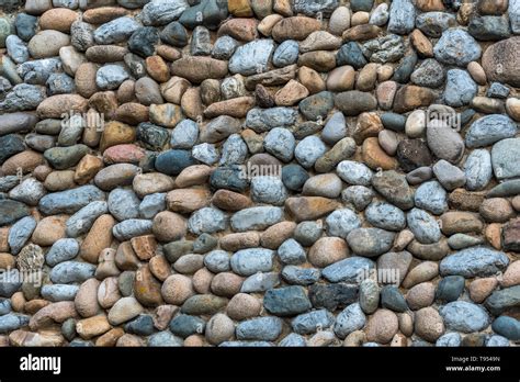 Different types of stones and pebbles of similar size arranged on flat ...